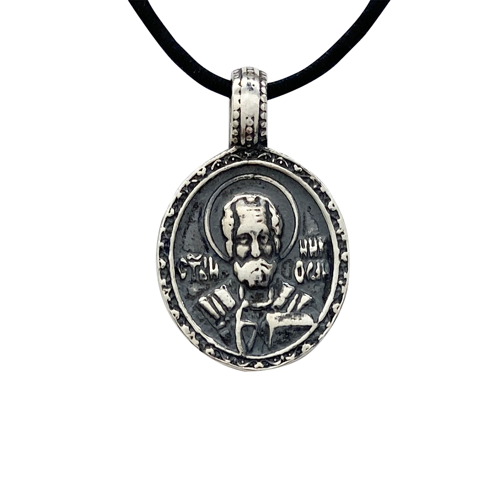Silver pendant featuring a religious icon of Saint Nicholas, on a whitebackground.