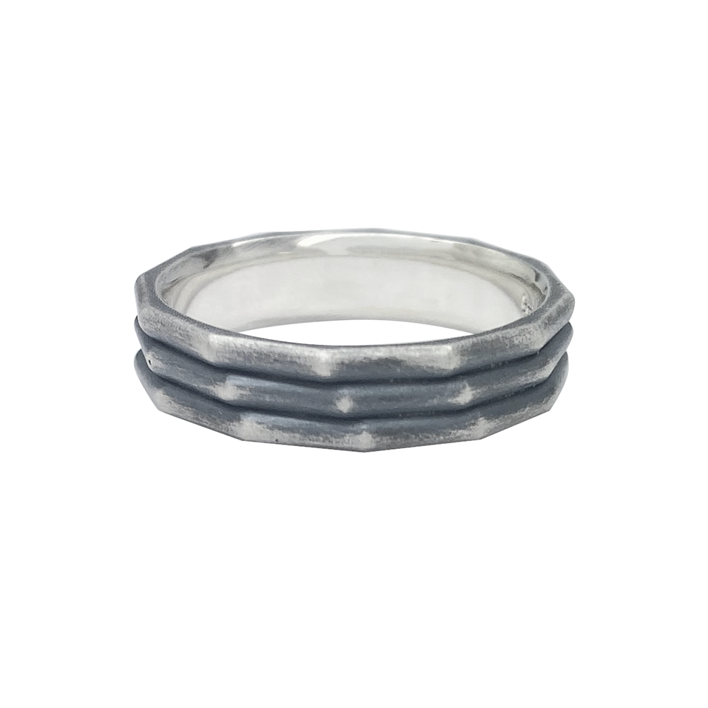 Silver ring with a textured, hammered band on a white background.