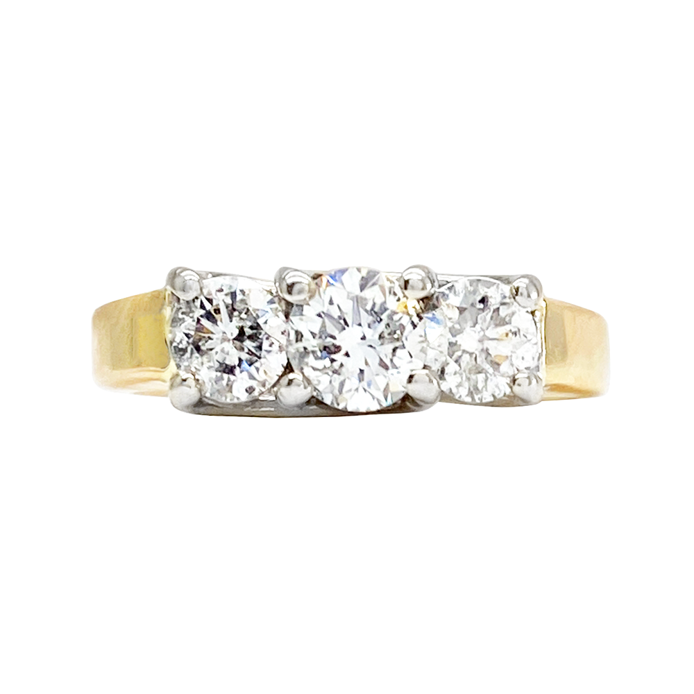 Yellow gold ring with three round diamonds in a three-stone setting, on a white background.