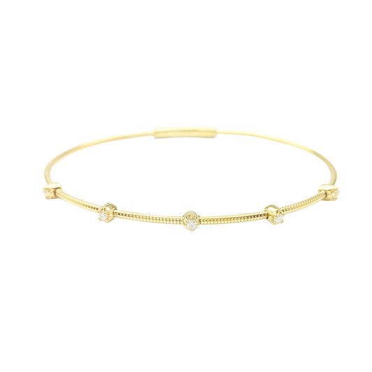 Gold bangle bracelet with four round diamonds evenly spaced along its length, on a white background.