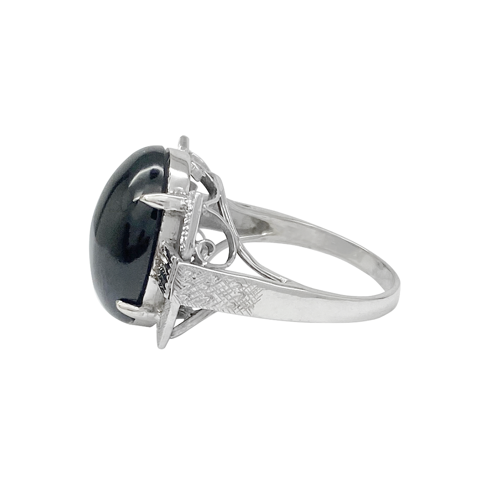 Silver ring with a black oval gemstone on a white background.