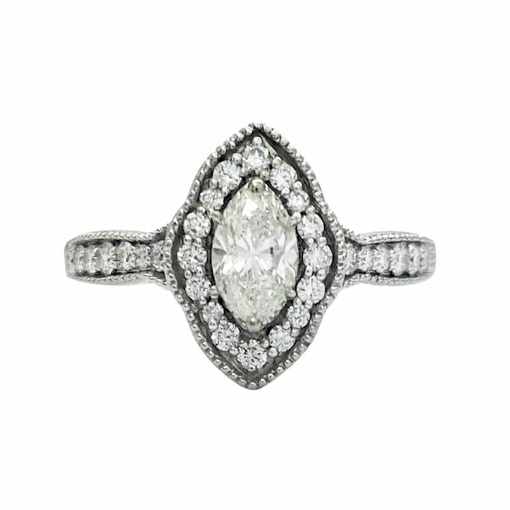 Silver marquise-cut diamond engagement ring with a halo of smaller diamonds and diamond-encrusted band.