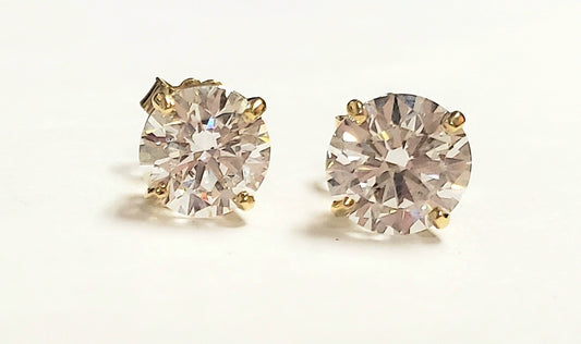 Pair of yellow diamond stud earrings in gold settings.