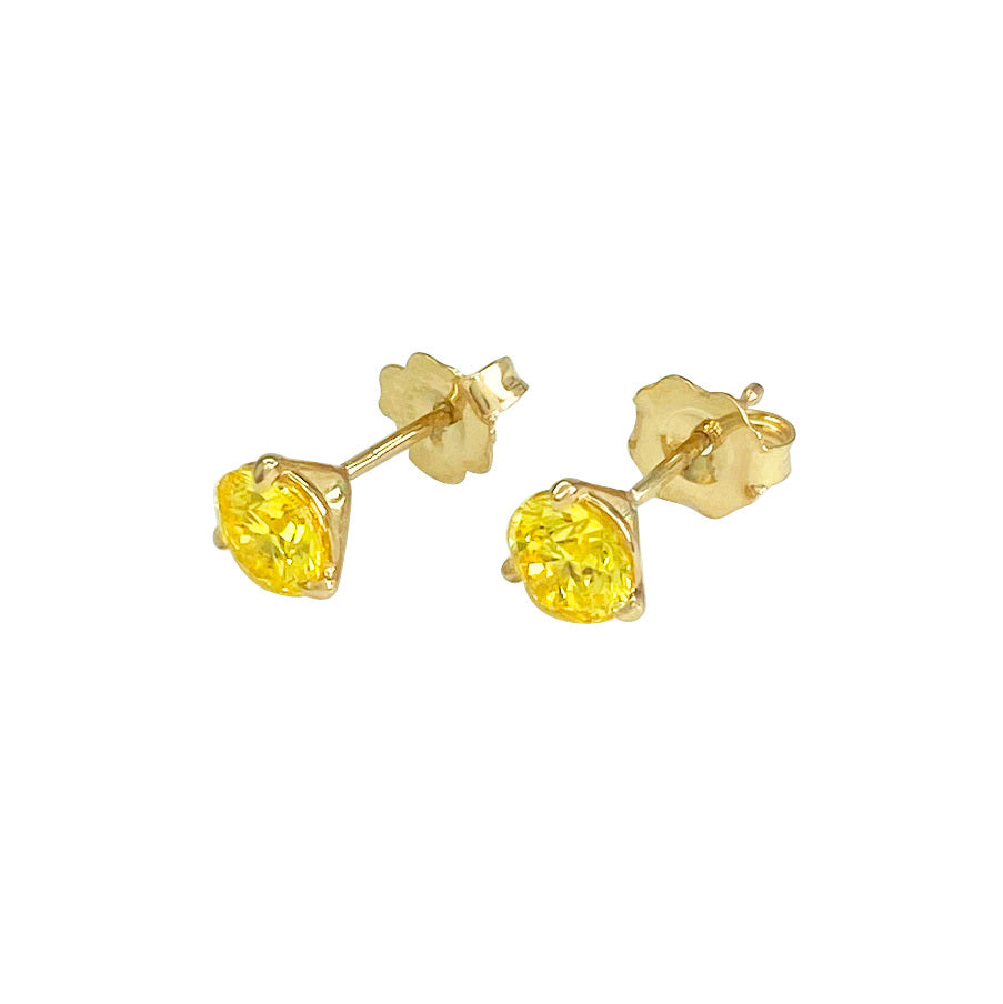 Pair of gold yellow diamond stud earrings on  a white background.