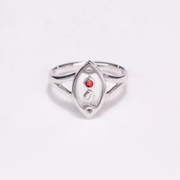 Silver ring with a red gemstone on a light gray background