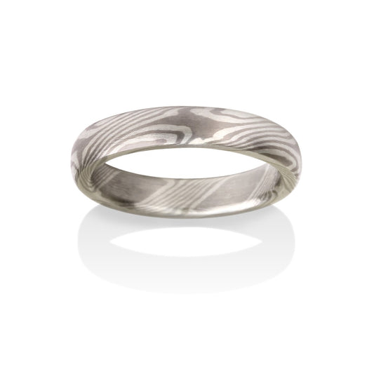 Silver ring with a Damascus steel pattern on a white background.