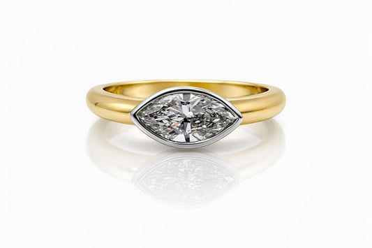 Gold ring with a marquise diamond on a white background
