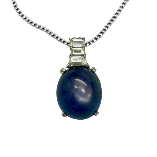 Blue sapphire gemstone pendant with silver chain on a white background