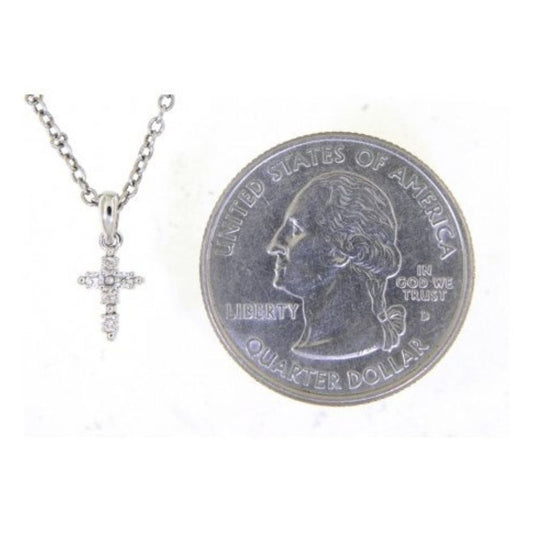 Silver cross necklace next to a U.S. quarter dollar coin on a white background