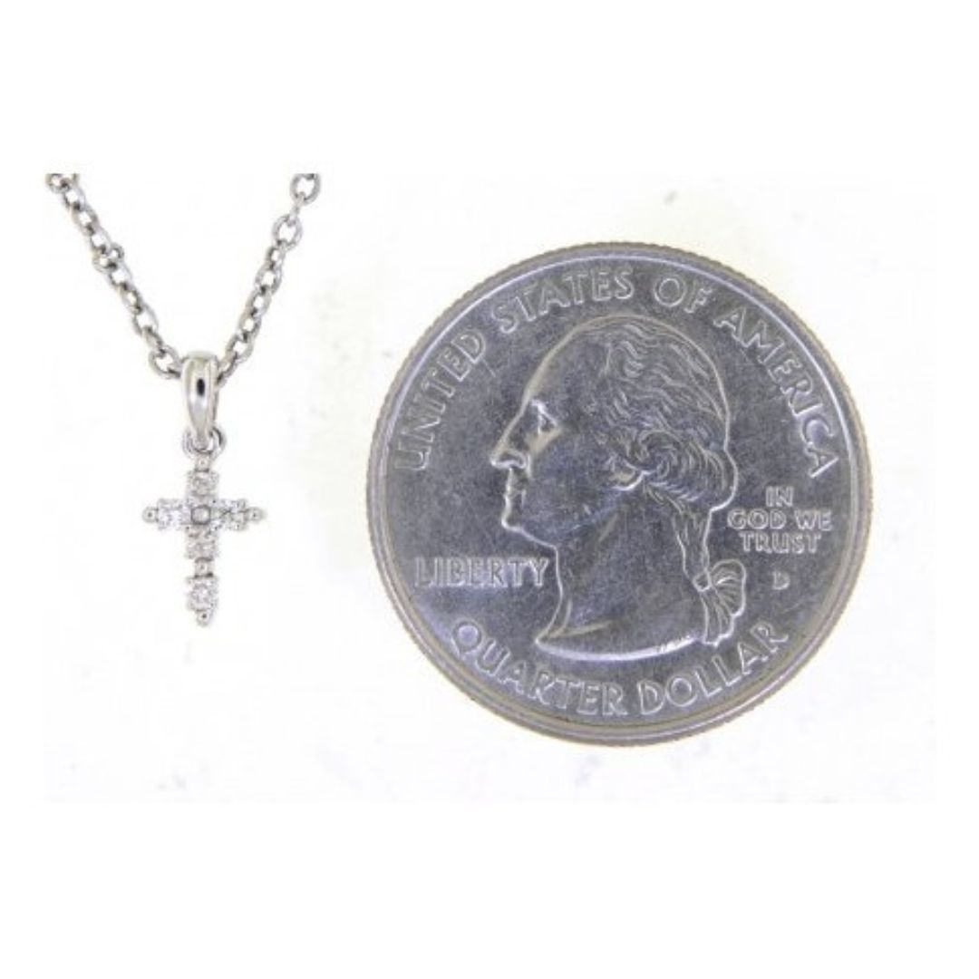 Silver necklace with a cross pendant next to a U.S. quarter dollar coin on a white background