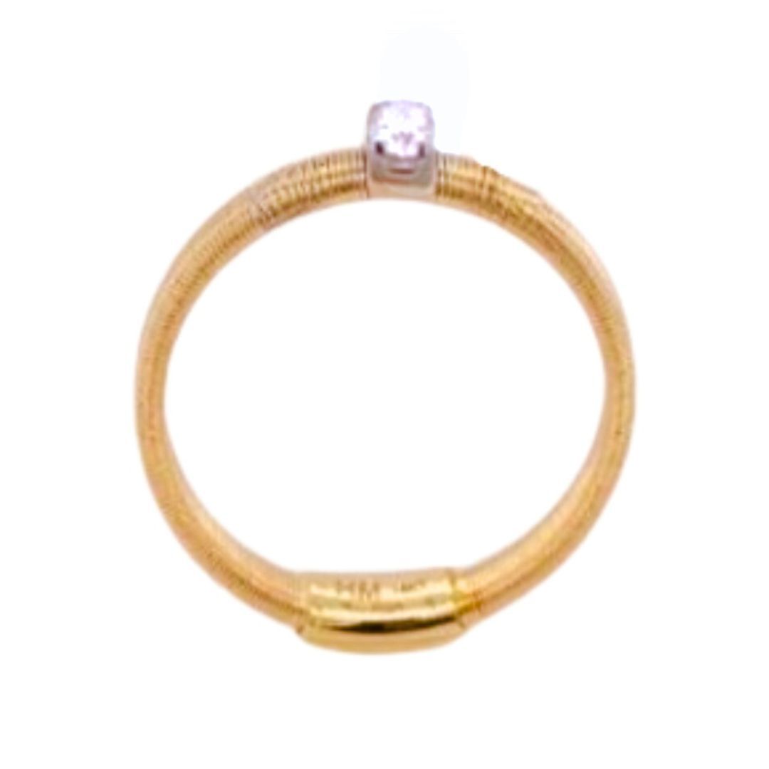 Gold ring with a silver bead on a white background