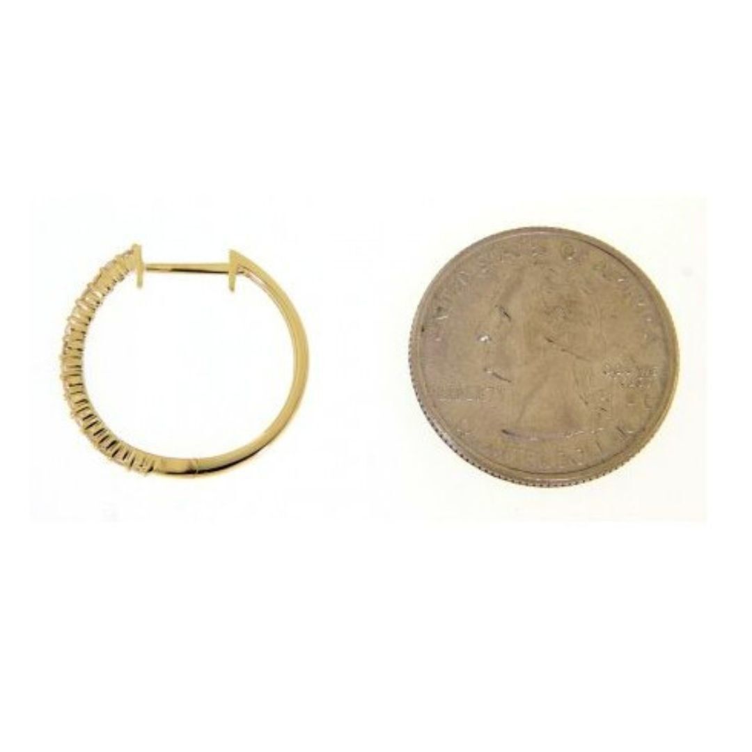 Gold hoop earring next to a penny on a white background