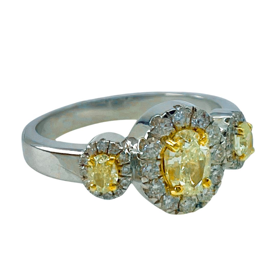 Silver ring with yellow gemstones and diamonds on a white background