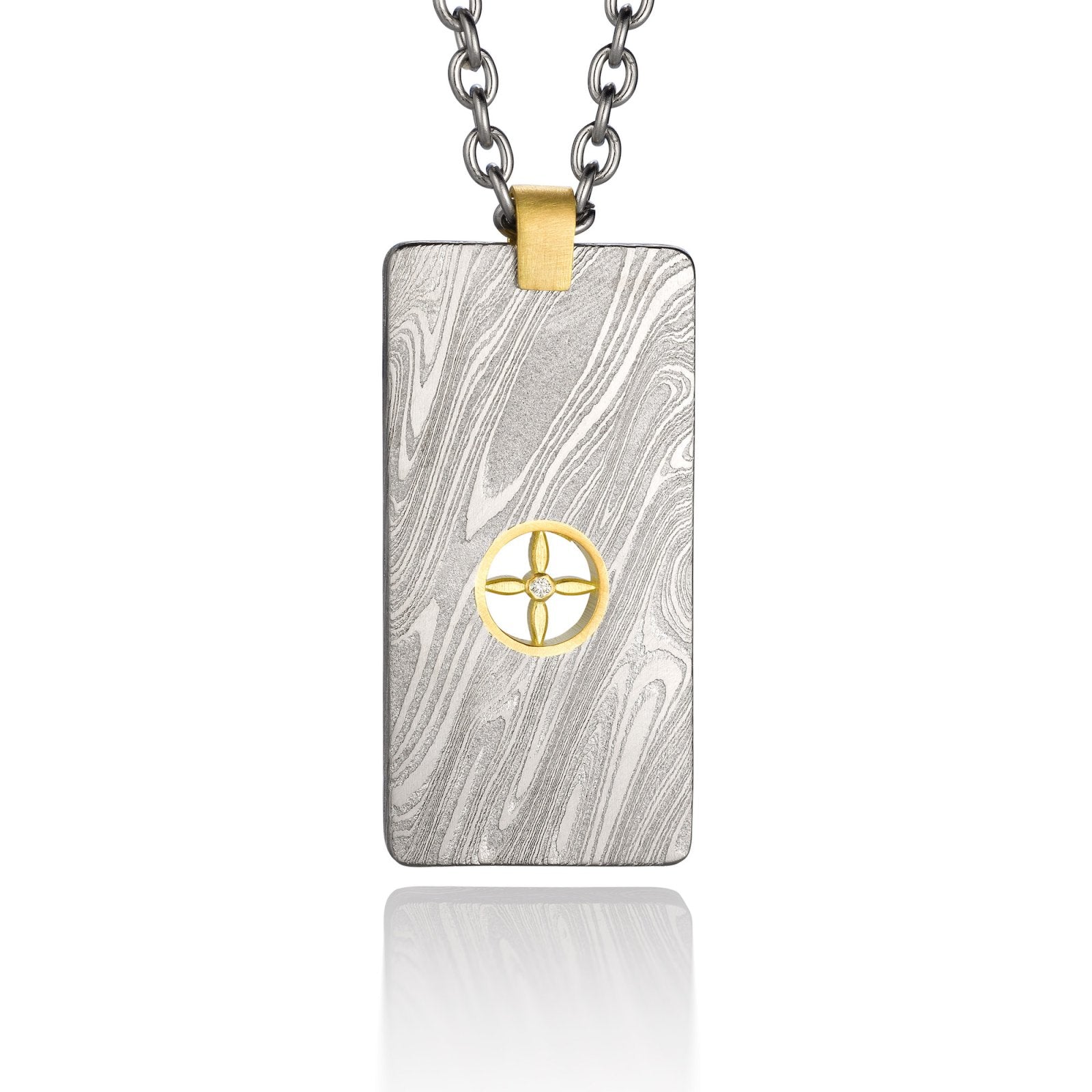 Silver shield-shaped Damascus necklace on a white background. 