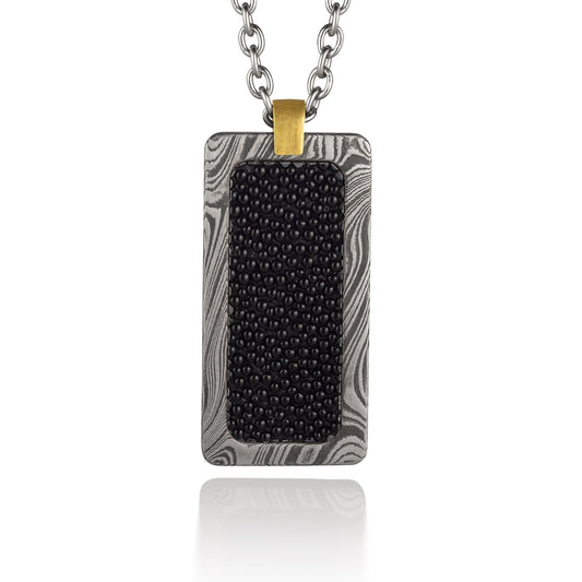 Silver rectangular pendant with a black center piece and a gold top, on a white background.