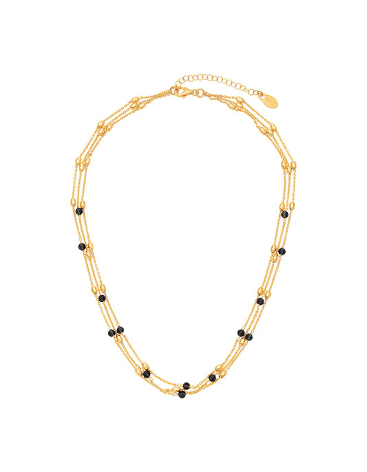Gold necklace with black beads on a white background