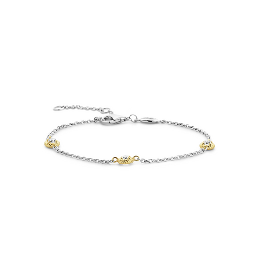 Bracelet with gold and silver charms on a white background