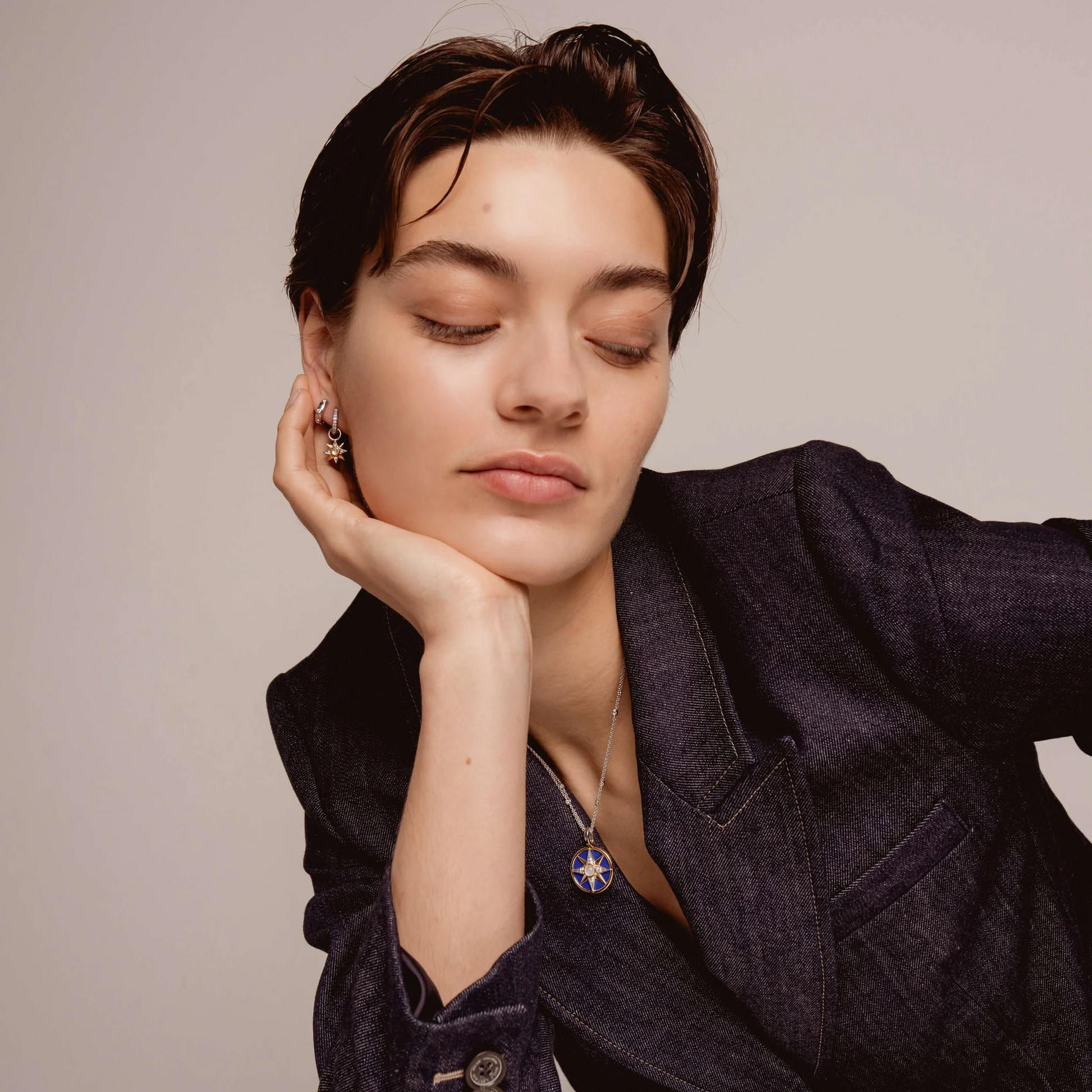 Woman wearing a dark blazer with a neutral background