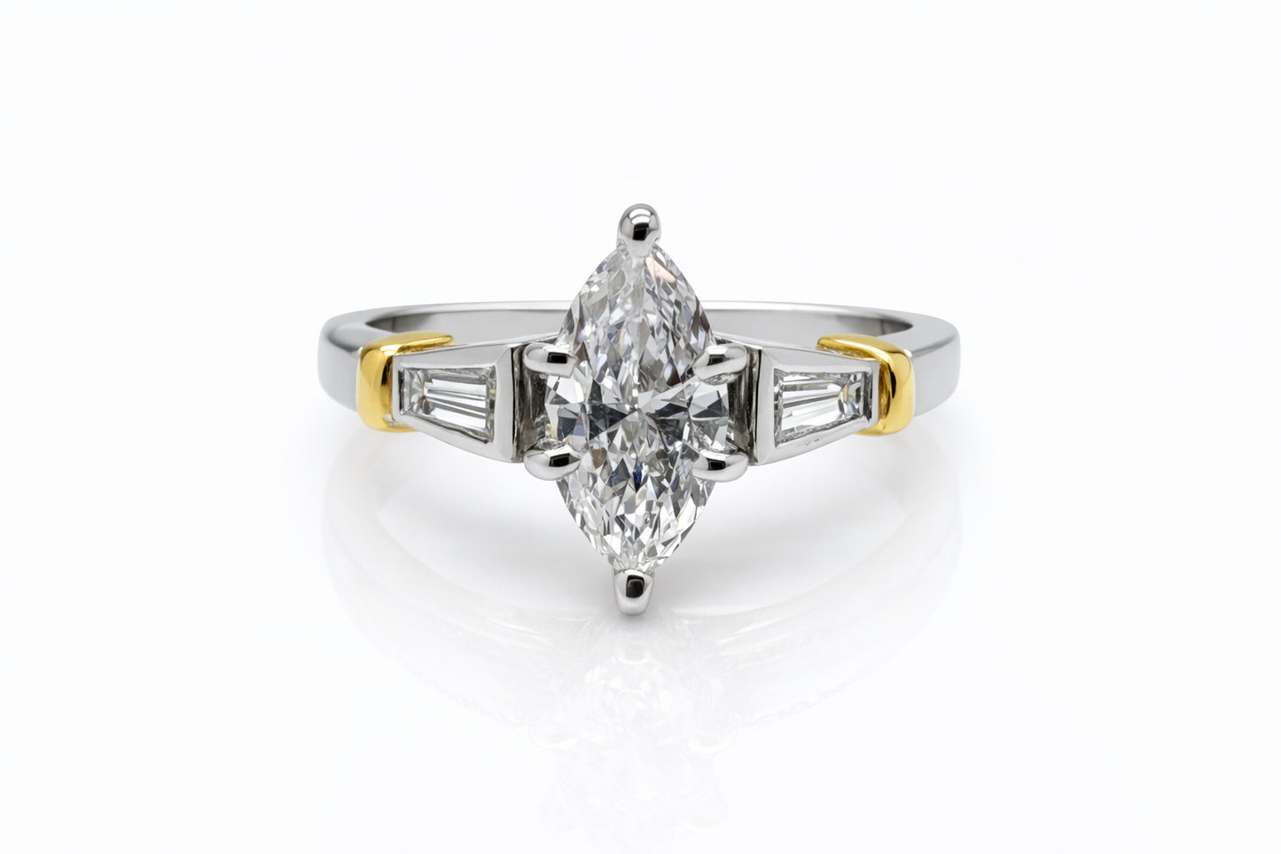 Diamond ring with a pear-shaped center stone on a white background
