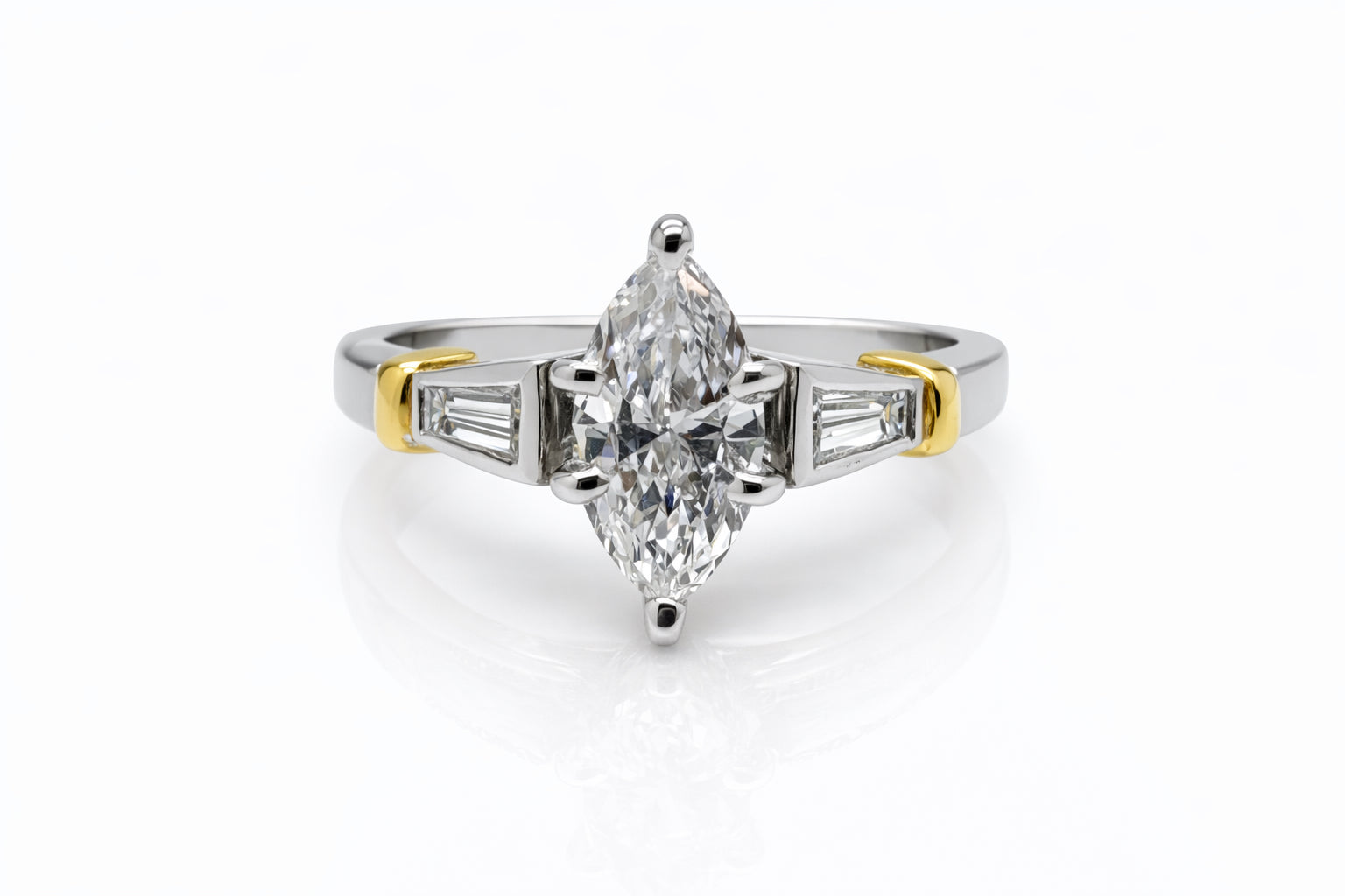 Diamond ring with a pear-shaped center stone on a white background