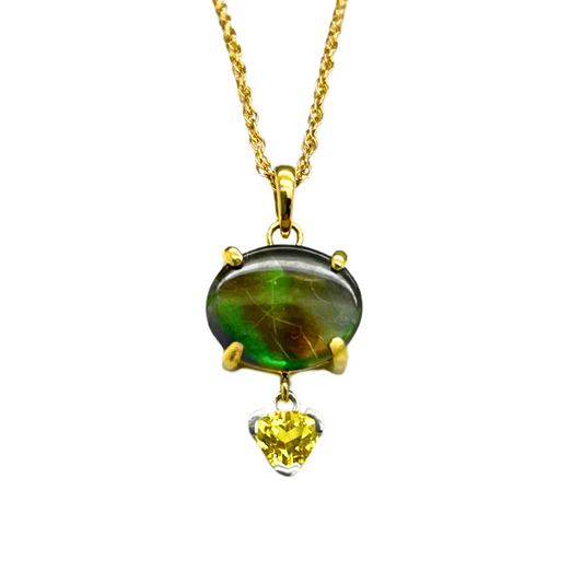 Yellow gold necklace with a green gemstone pendant on a white background