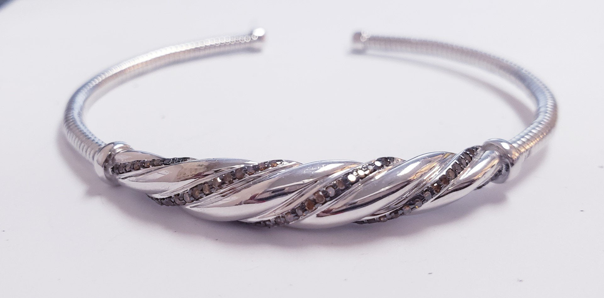 Silver bangle wirh gemstone, on a table