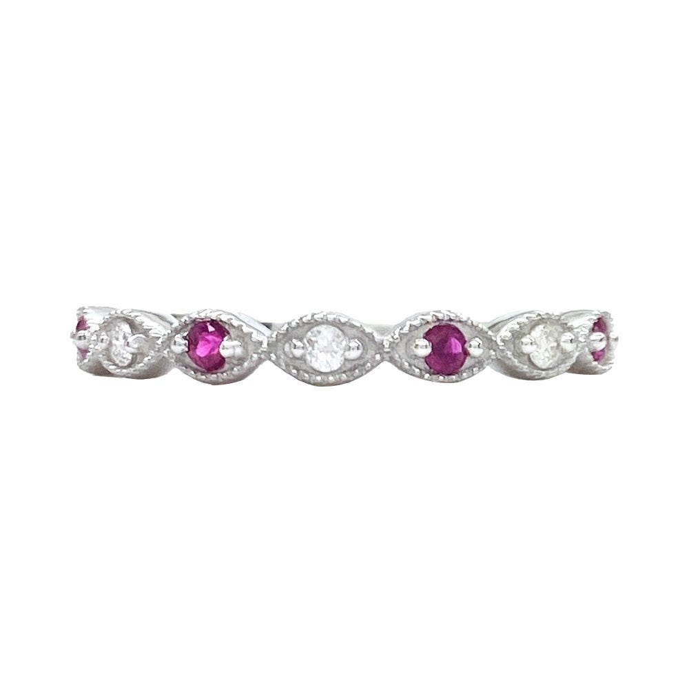 Silver ring with oval rubies and diamonds set in a delicate, scalloped pattern. The background is white.